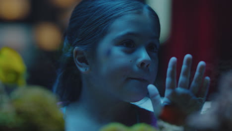 cute little girl in aquarium looking at fish curious child watching colorful sea life swimming in tank learning about marine animals in underwater ecosystem inquisitive kid at oceanarium