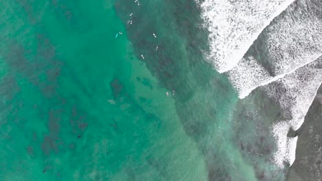 Aerial view of surf break and Surfers on a gloomy morning