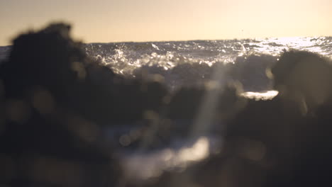 ocean waves crashing on rocks with early morning sun