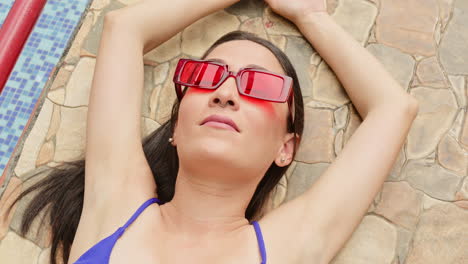 slow motion shot of a swimwear model posing at the side of the pool