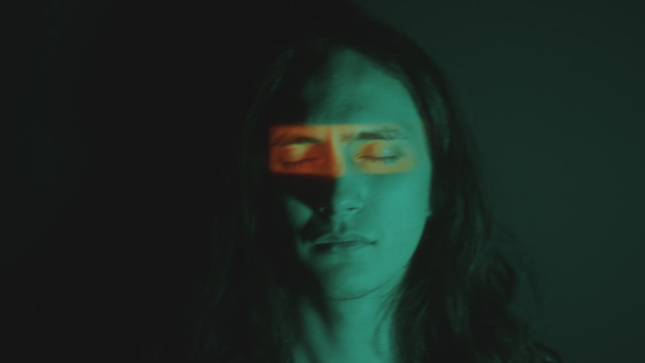 Portrait of Young Handsome Man with Eyes Closed in Dark Studio