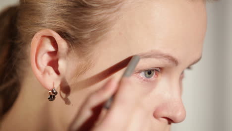 una mujer joven moldeando sus cejas.