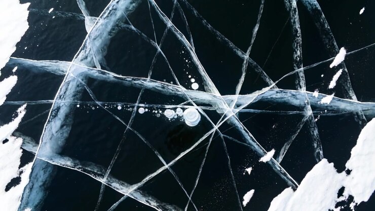 Taking off drone capturing crossing ice cracks on lake ice, filming bubble trail for mapping