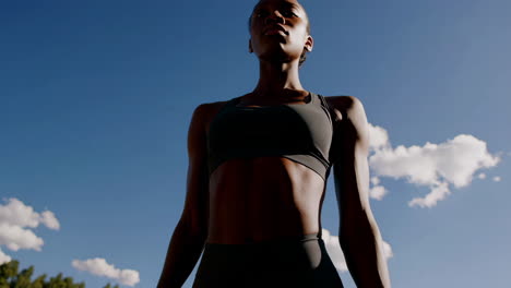 dynamic woman stretching outdoors under blue sky