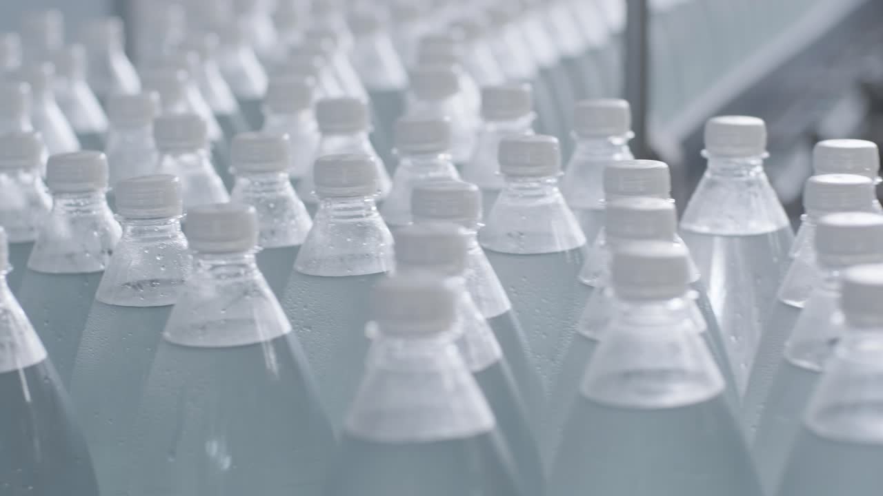 cinta transportadora con botellas de agua potable en una planta de bebidas moderna
