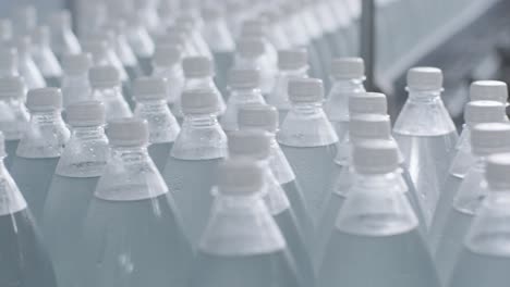 cinta transportadora con botellas de agua potable en una planta de bebidas moderna