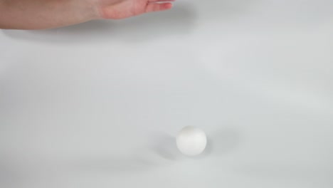 hand drops a soft ball onto surface