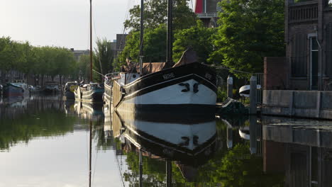 barco vintage amarrado en el canal turfsingel con reflejo espejado en gouda, países bajos