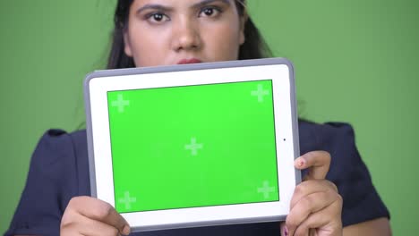 joven sobrepeso hermosa mujer de negocios india contra fondo verde