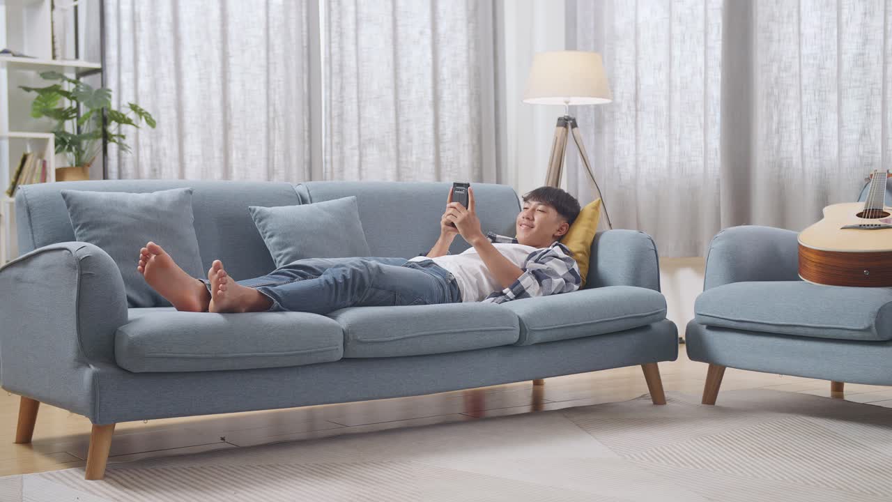 스마트폰으로 소파에서 휴식을 취하는 십대