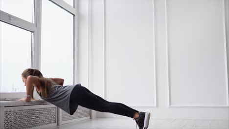 woman doing push-ups near a window