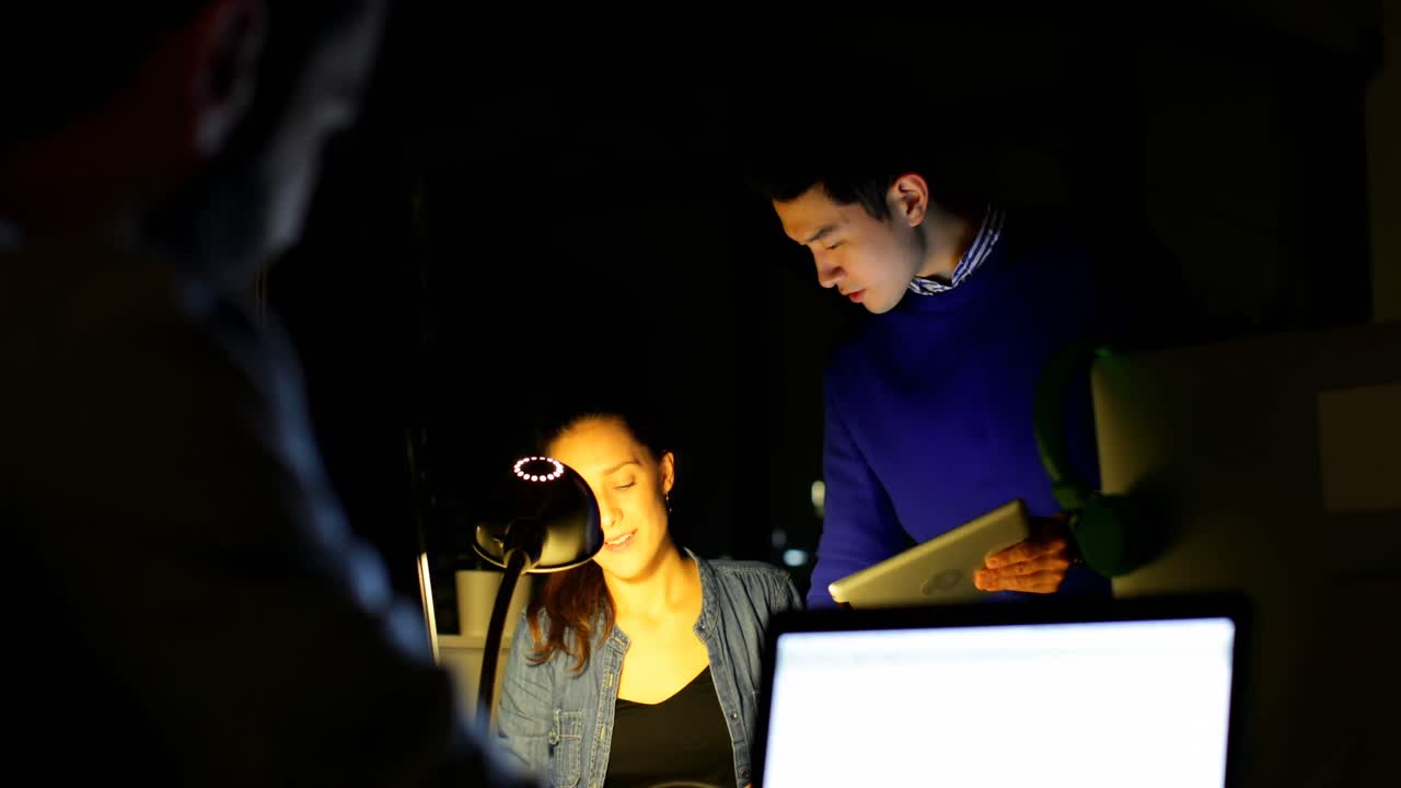 비즈니스 동료 들 이 사무실 4k 의 책상 에서 디지털 태블릿 을 통해 논의 하고 있다