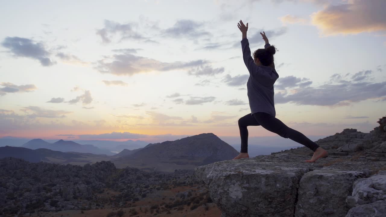 mujer concentrada practicando yoga en las montañas al atardecer