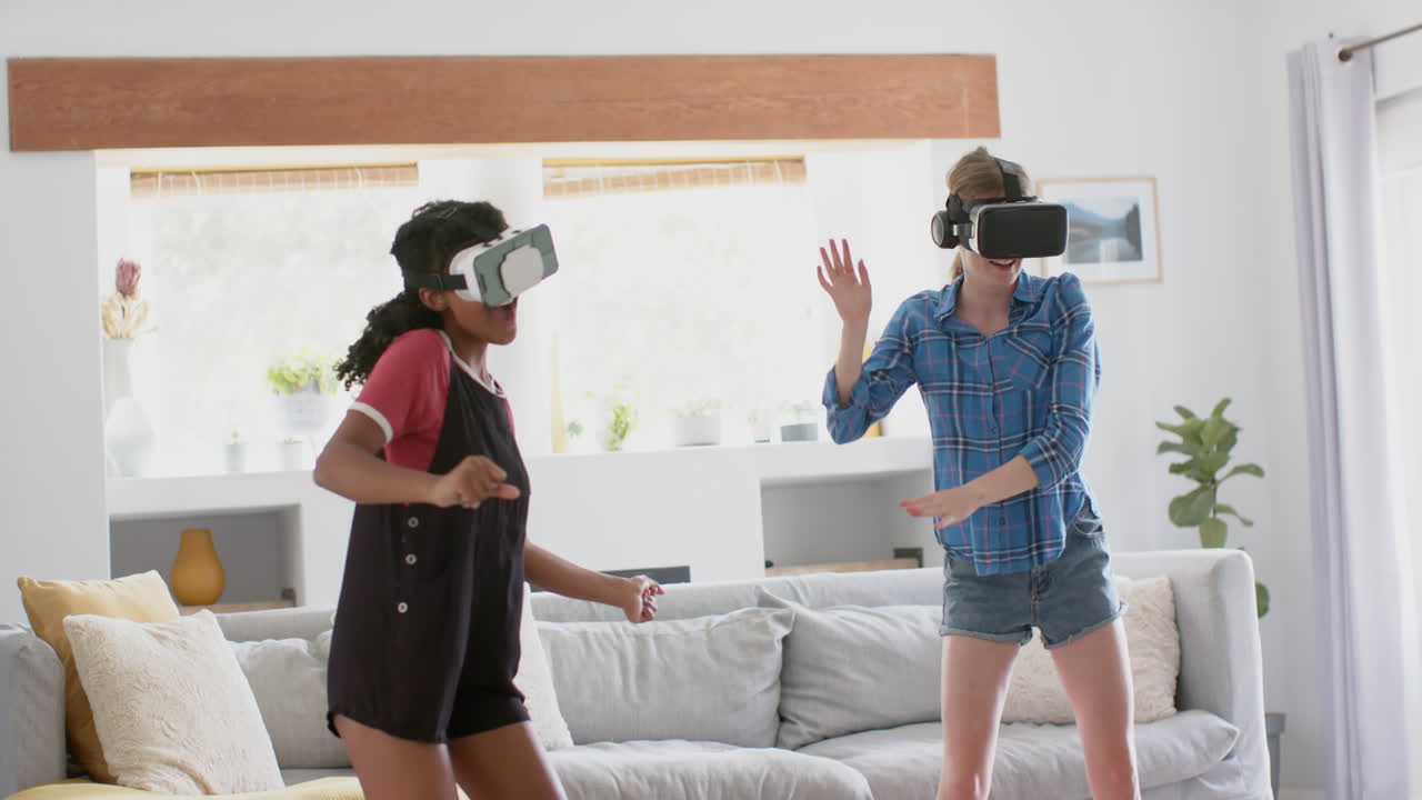amigas adolescentes felices y diversas jugando y usando auriculares vr en casa, en cámara lenta