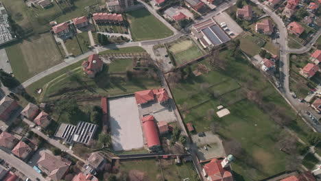 Bird's-Eye-View-Of-Rural-Landscape-With-Green-Fields-And-Houses-On-A-Sunny-Day-In-Italy---aerial-drone-shot