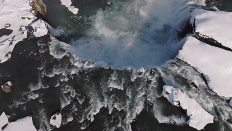 Vista-Aérea-De-La-Hermosa-Cascada-En-El-Norte-De-Islandia-En-El-Soleado-Día-De-Invierno,-Agua-Glacial-Y-Paisaje-Nevado