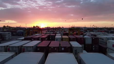a breathtaking sunset over a bustling shipping yard, showcasing colorful containers silhouetted against the sky, creating a stunning visual contrast and vibrant atmosphere.