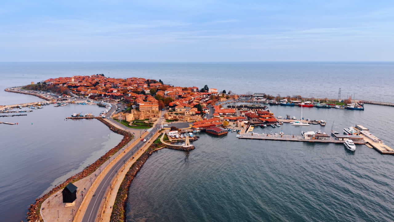 Malerisk del af Nessebar, Bulgarien omgivet af havvand. Luftperspektiv af ferieområdet med røde tage på en dyster dag.