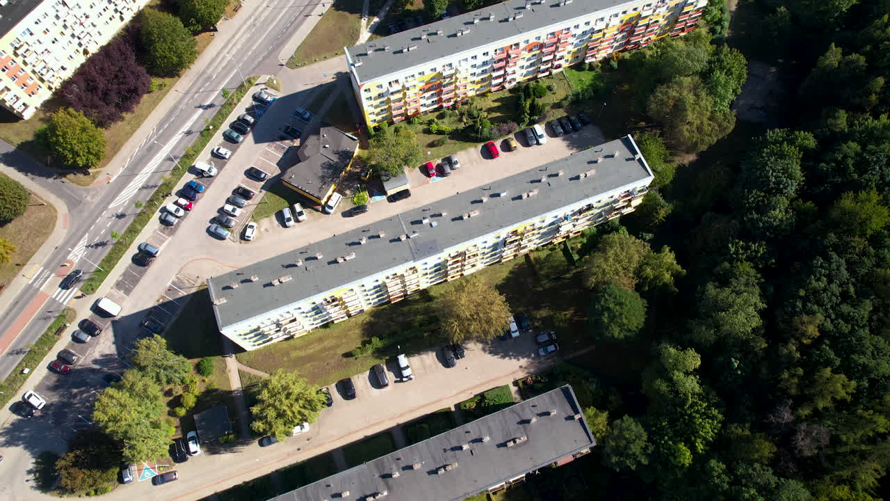 Luftfoto ovenfra over et boligblokkvarter i en polsk by med parkerede biler og hustag
