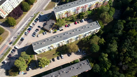 aerial top down flight over block neighborhood in polish city with parking cars and rooftop of house