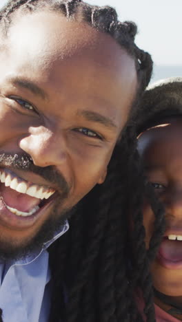 video of happy african american father and son in helmet taking selfie outdoors