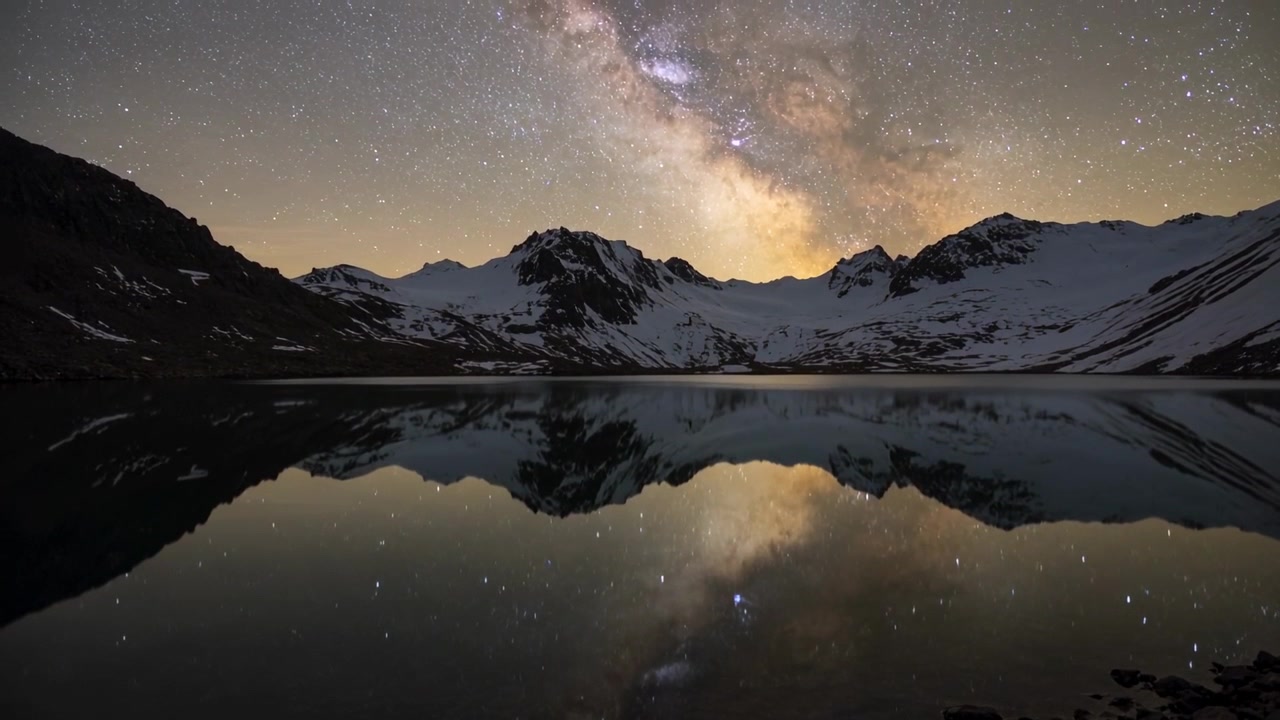 Avvio del timer: la Via Lattea sorge e cresce sopra una cresta alpina, con un lago che riflette e mostra il movimento del cielo.