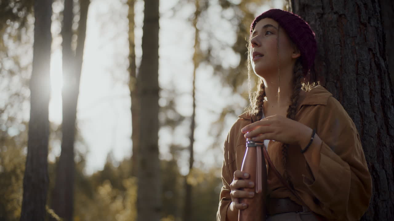 turista mujer abriendo la tapa de la botella después de explorar el bosque