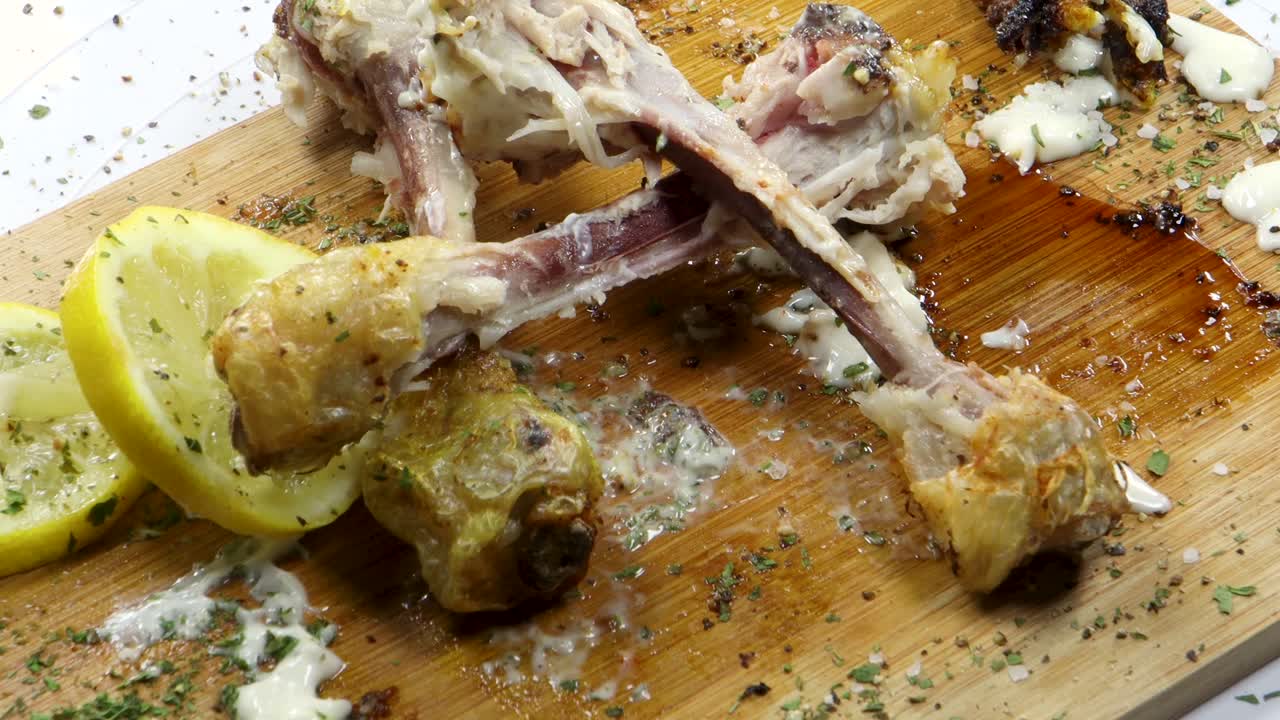 mano recogiendo huesos de pollo comido con restos de carne