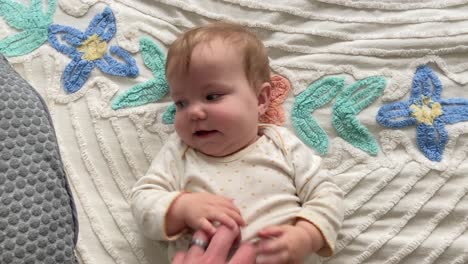 happy, cute, young, baby girl smiling while being tickled by her parent