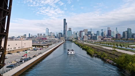 drone shot following a passenger ferry passing the train yard in sunny chicago