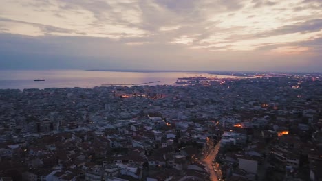 aerial footage of coastal city of thessaloniki by dusk, drone panning