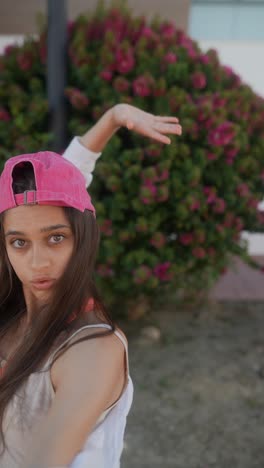 young woman wearing a pink baseball cap outdoors