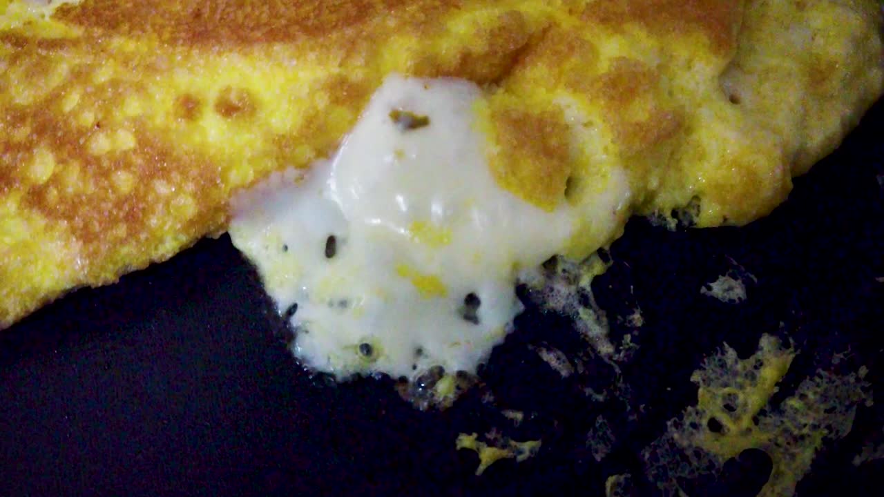 Static shot of cheese at boiling point on a tortilla during its preparation and cooking process in Mexico City
