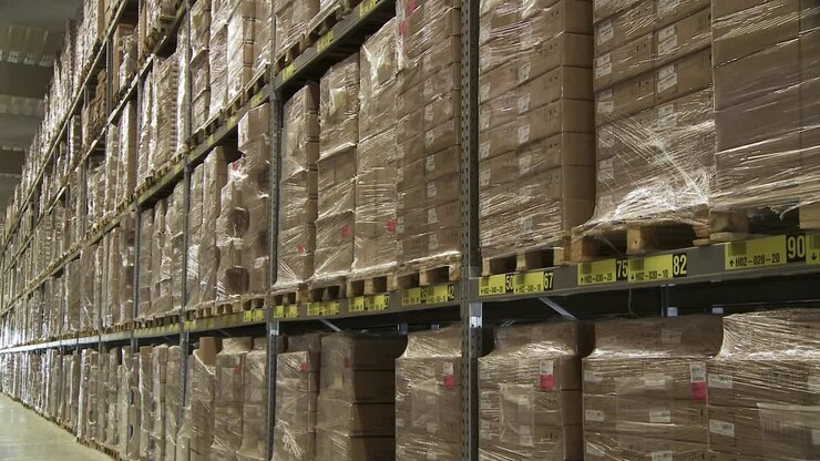 Enorme magazzino con scatole di cartone su pallet