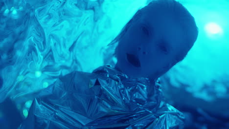 alien woman in tin foil dress posing in laser light