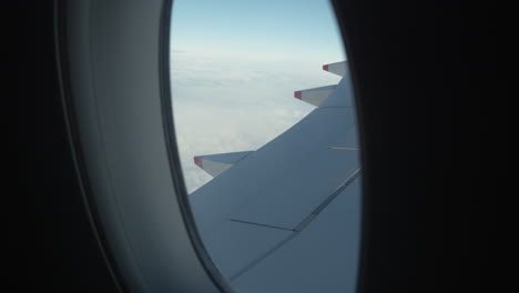 airplane wing through window. slow motion, push in