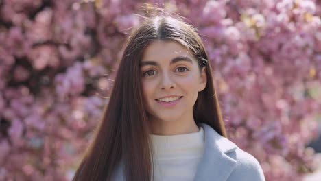 woman in a blue coat with cherry blossoms