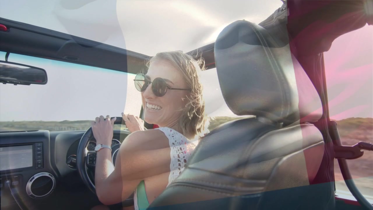 Female driver driving coast road, sun causing shades adjusting while lens flares pulsing for travel