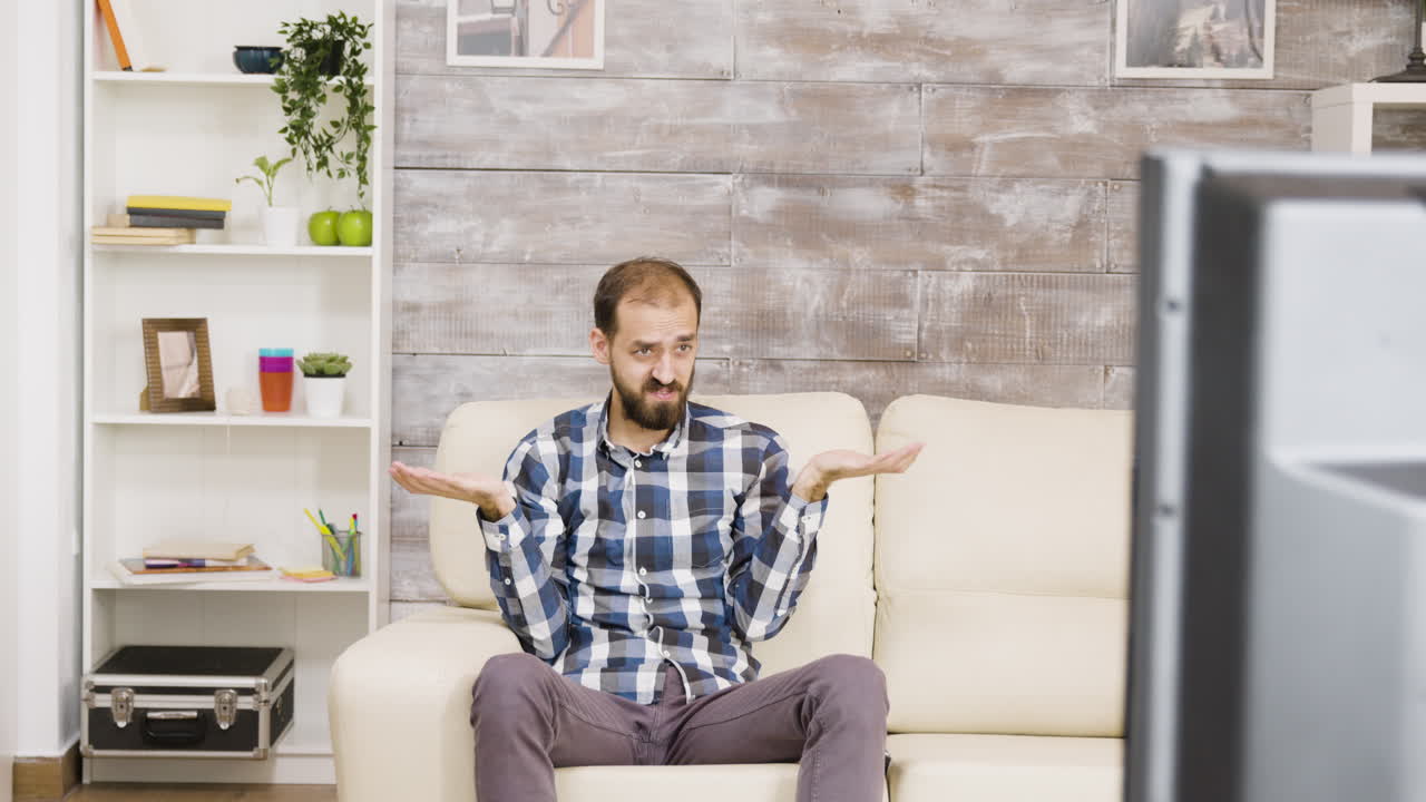 A man watching television on a sofa
