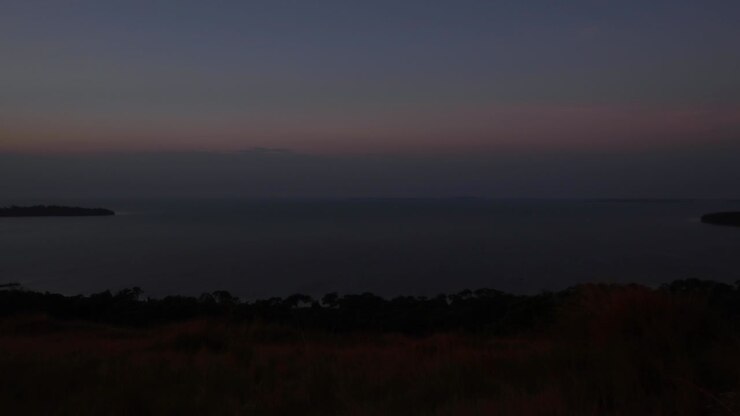 Time lapse del tramonto sul Lago Vittoria. Vista dell'arcipelago (Isole Ssese) da una collina a Kalangala, Uganda. Raffiche di vento sull'acqua, isole e orizzonte visibile