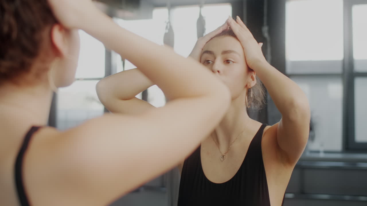 Woman Checking Her Hair in the Gym