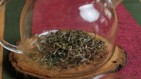 glass teapot with green tea leaves