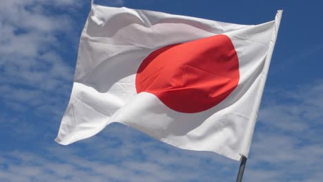 bandera japonesa ondeando en el viento en cámara lenta cerca con el fondo del cielo