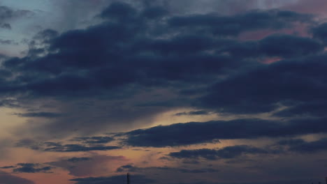 Una-Hermosa-Vista-De-Las-Nubes-Que-Se-Mueven-Suavemente-En-El-Cielo,-Las-Nubes-Toman-Los-Colores-Naranja-Y-Purolvous-A-Un-Color-Oscuro