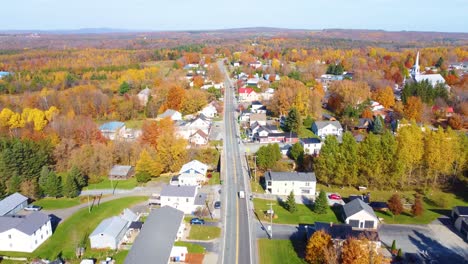 region of estrie with houses and streets surrounded by colorful autumn trees, quebec, canada.