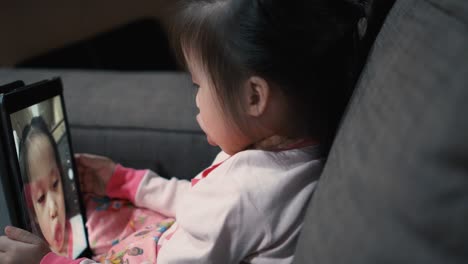 little girl using digital tablet and taking selfie