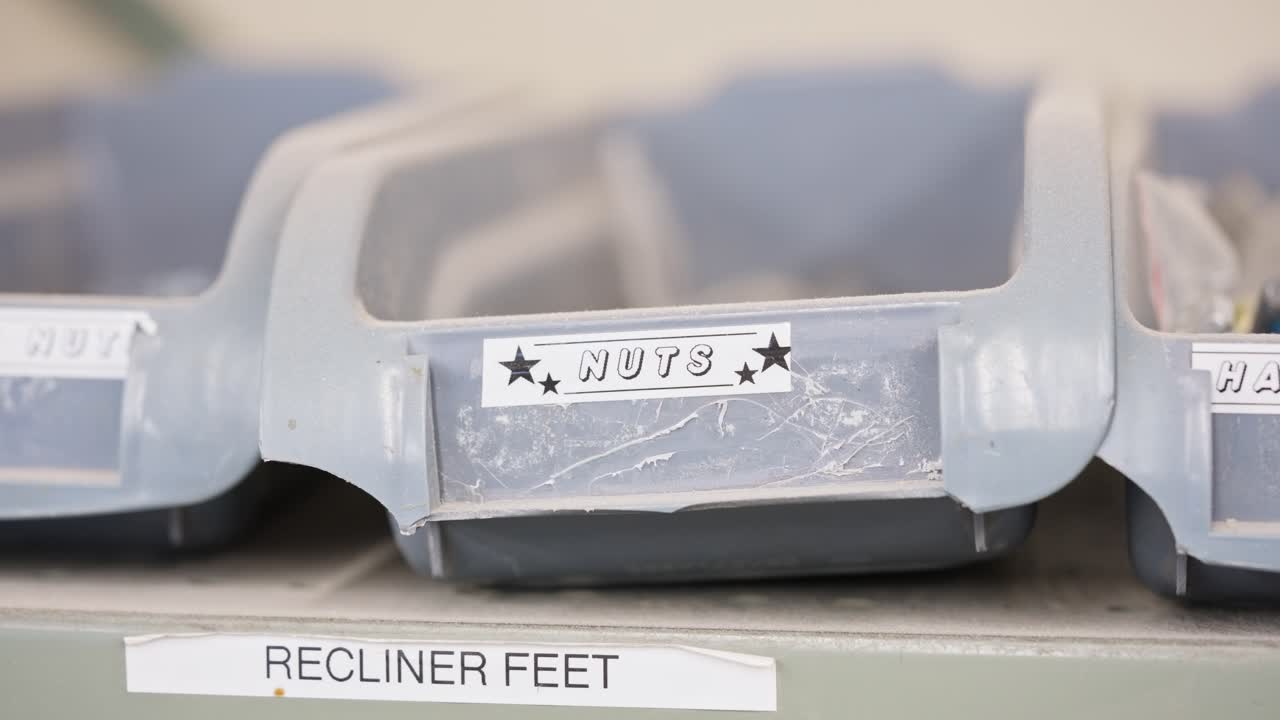 Static shot racks focus onto bin labeled nuts, full of metal fasteners