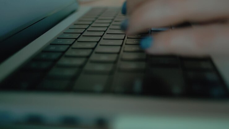 Frau, die auf einer Laptoptastatur tippt