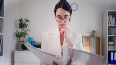 una mujer de negocios analiza un informe financiero en una carpeta.
