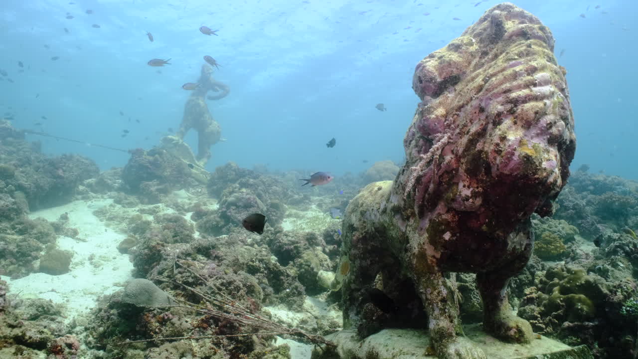 escultura de piedra grungy bajo el mar con peces nadando alrededor